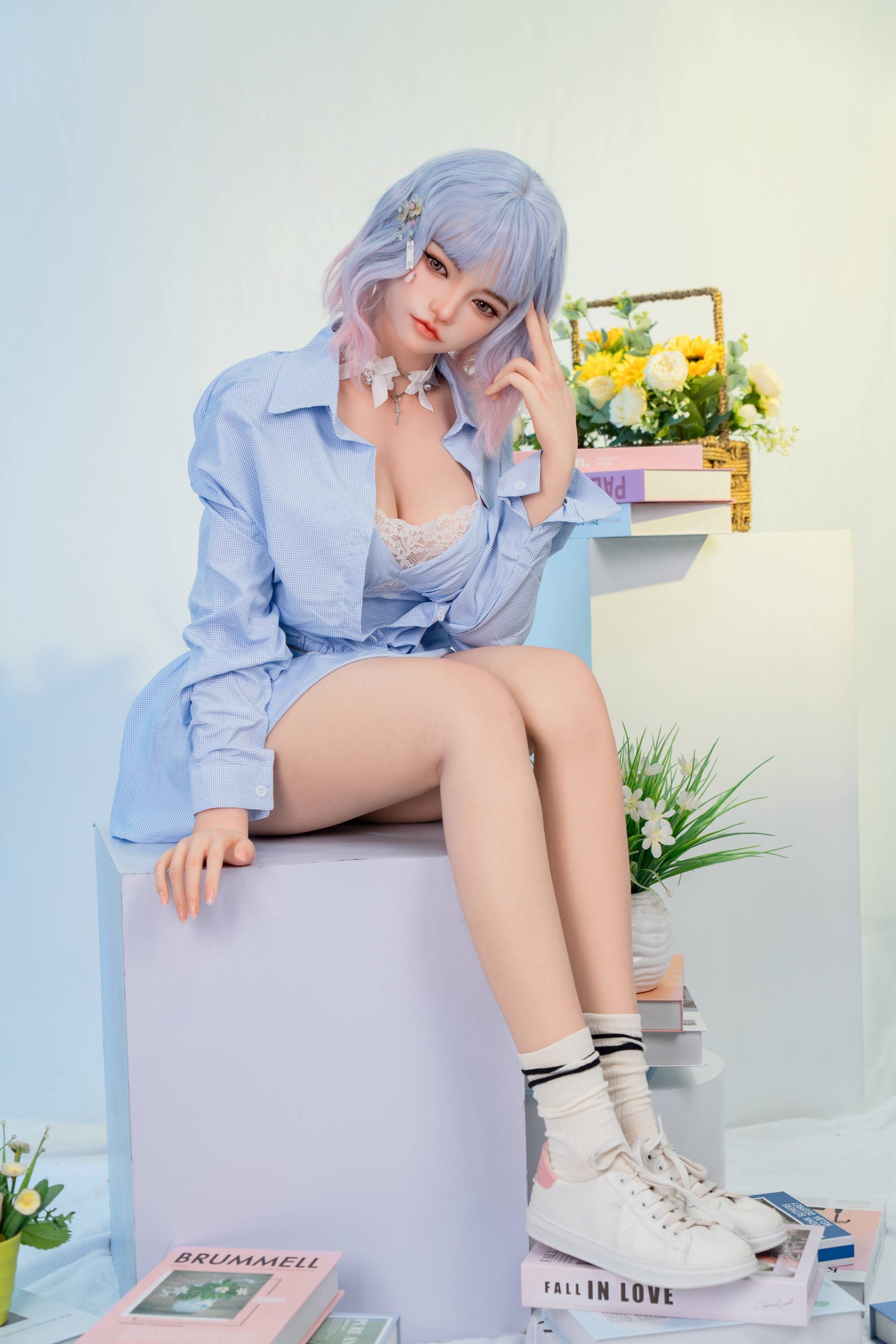 Silicone doll with pastel blue-and-pink bob hair wearing a light-blue outfit and white trainers