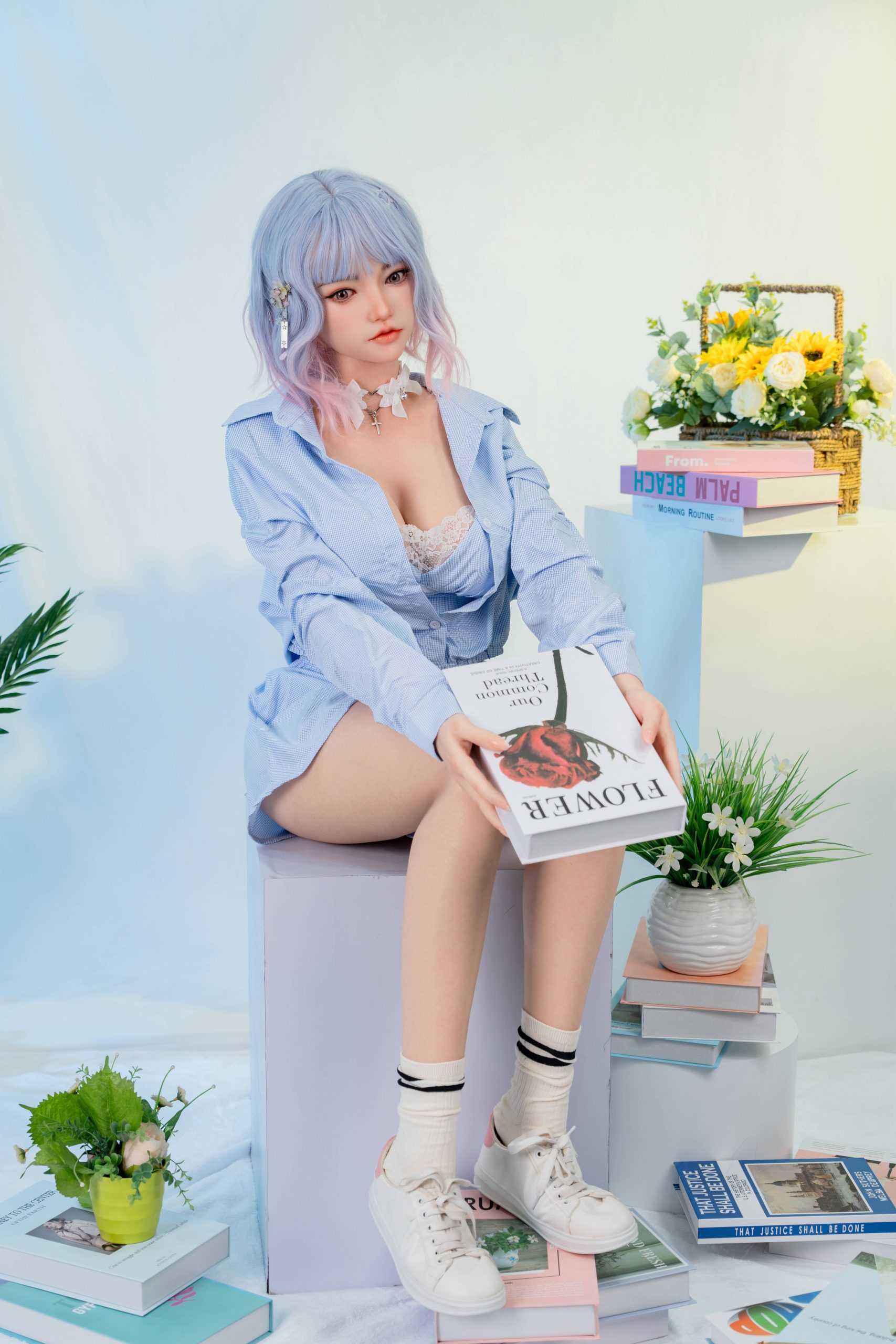Silicone doll with pastel blue-and-pink bob hair wearing a light-blue outfit and white trainers