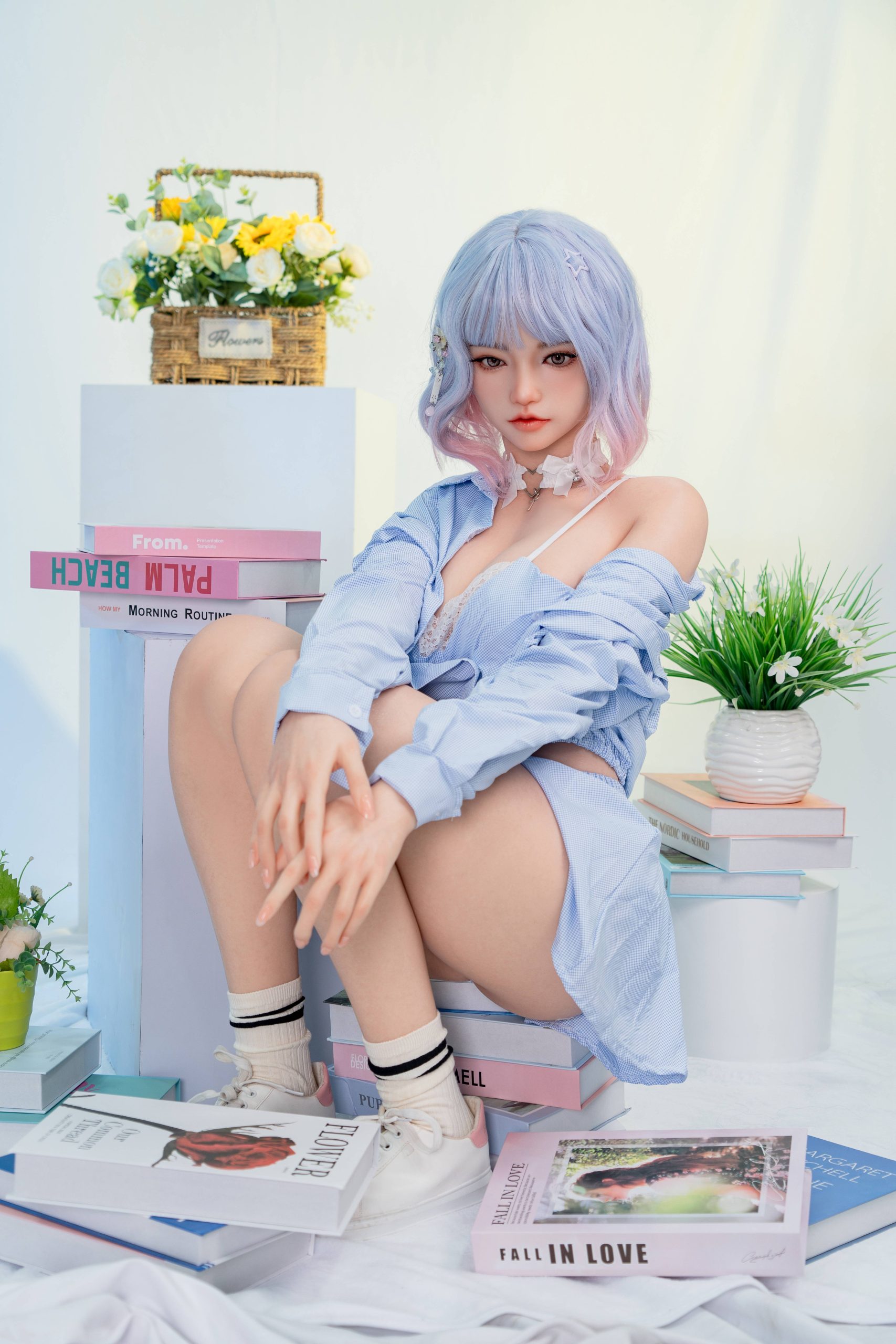 Silicone doll with pastel blue-and-pink bob hair wearing a light-blue outfit and white trainers