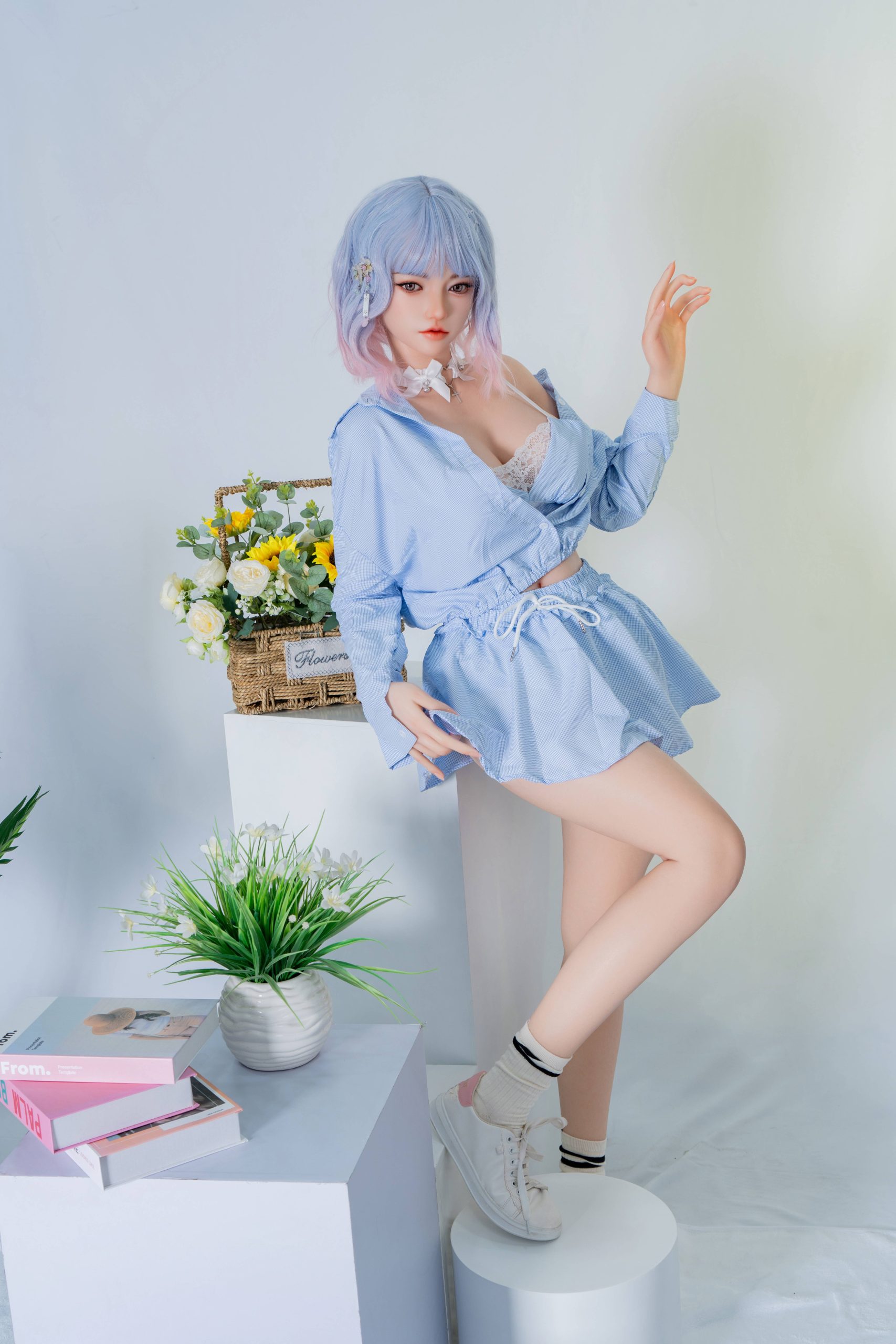 Silicone doll with pastel blue-and-pink bob hair wearing a light-blue outfit and white trainers