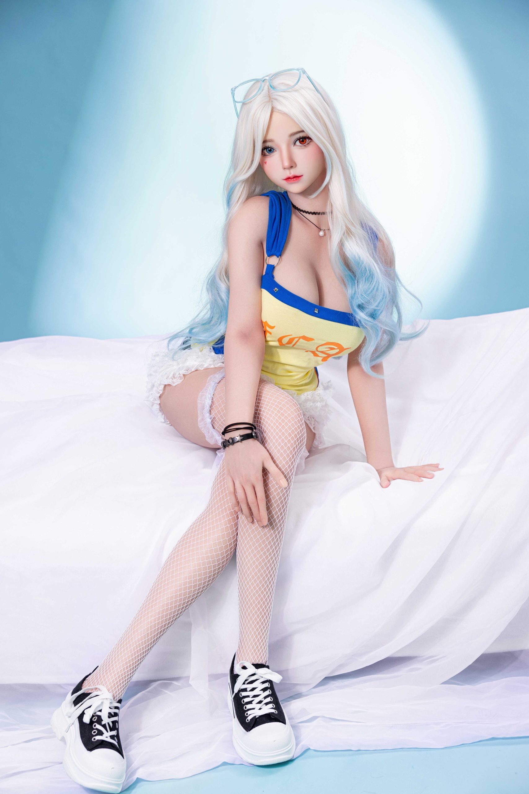 Silicone doll with white-blue hair seated in a yellow-and-blue outfit, white fishnet stockings and black trainers